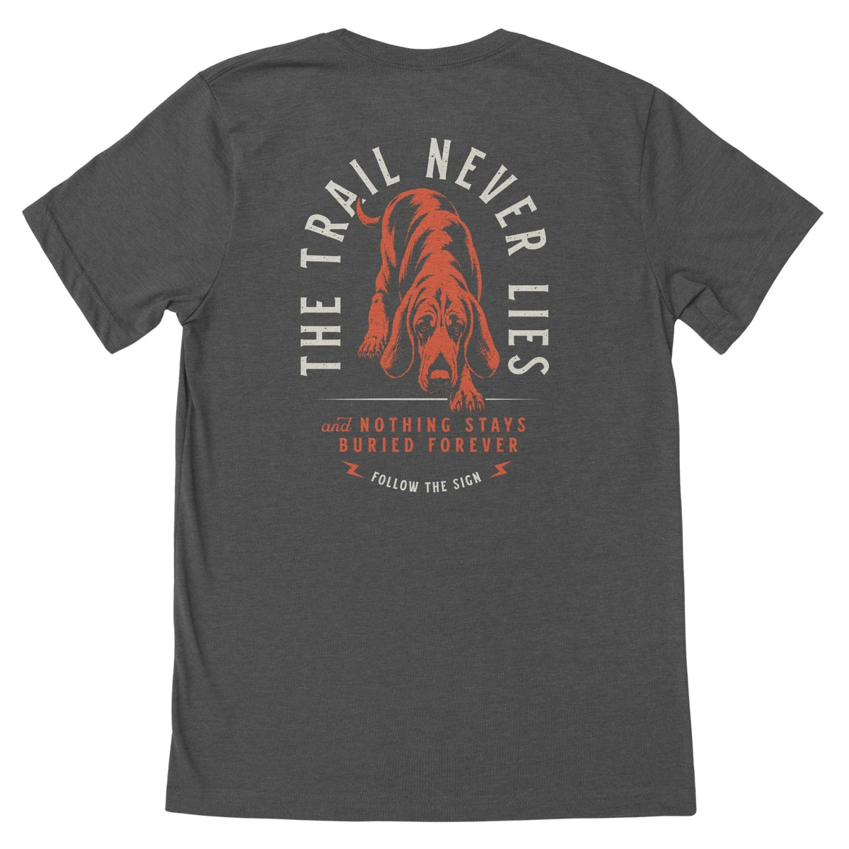 Charcoal heather T-shirt featuring a red hound and beige arched text "THE TRAIL NEVER LIES" above it, below there is red text "AND NOTHING STAYS BURIED FOREVER", beneath the text in beige "FOLLOW THE SIGN".