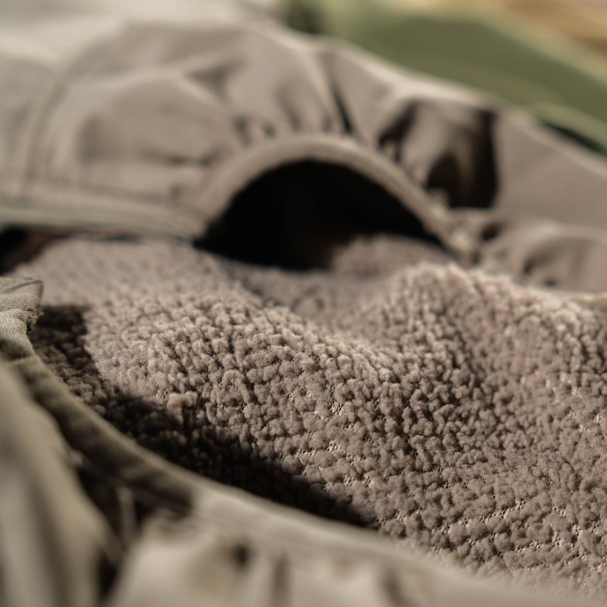 Olive green jacket with fuzzy brown sherpa lining.
