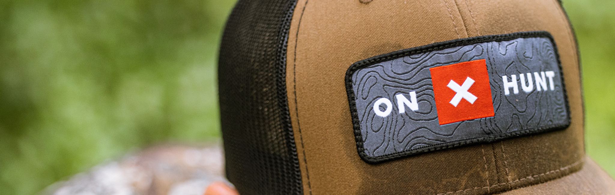 Brown & black trucker cap with 'ON X HUNT' topo patch, including a red X.