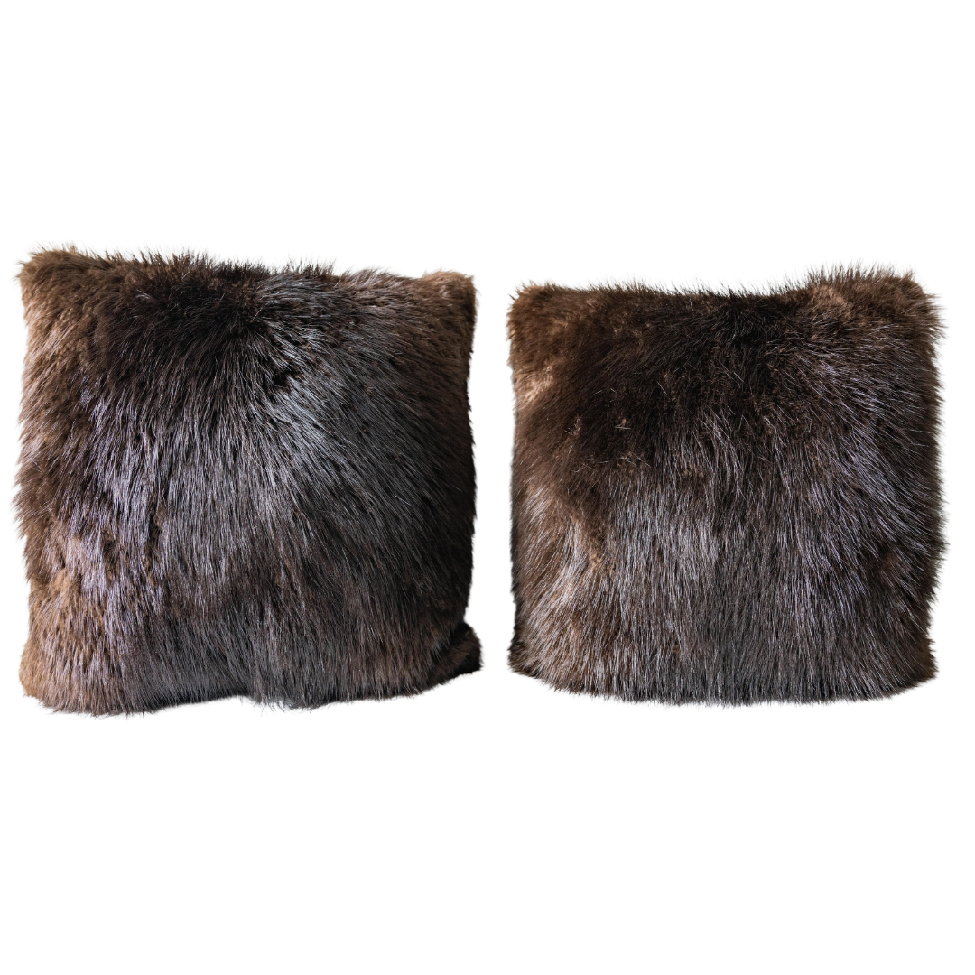 Two square dark brown faux fur pillows.