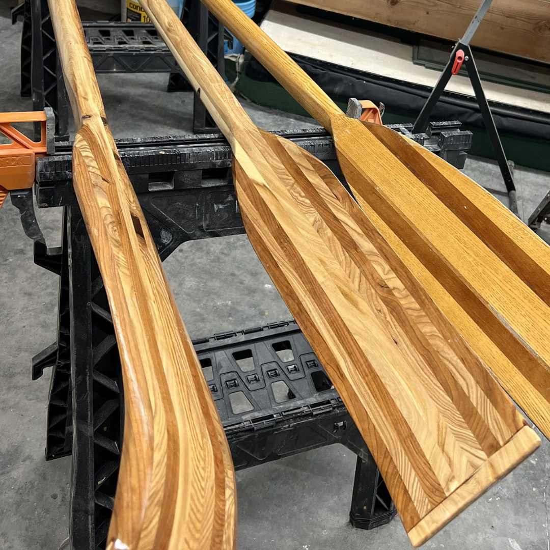Three natural wood paddles featuring distinct light and dark striped grain.