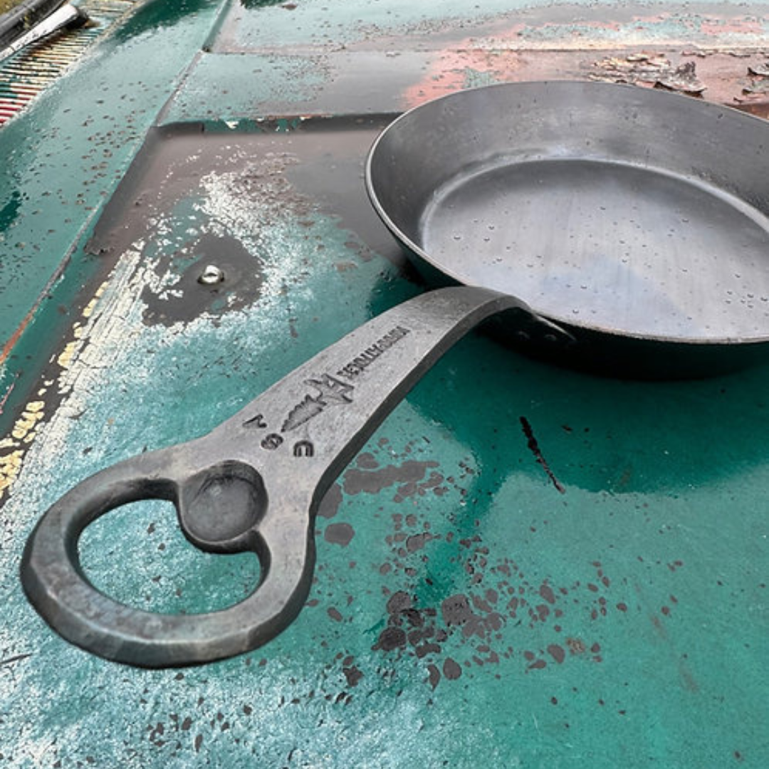 Dark gray metal skillet with bottle opener handle and VERATHORN logo.