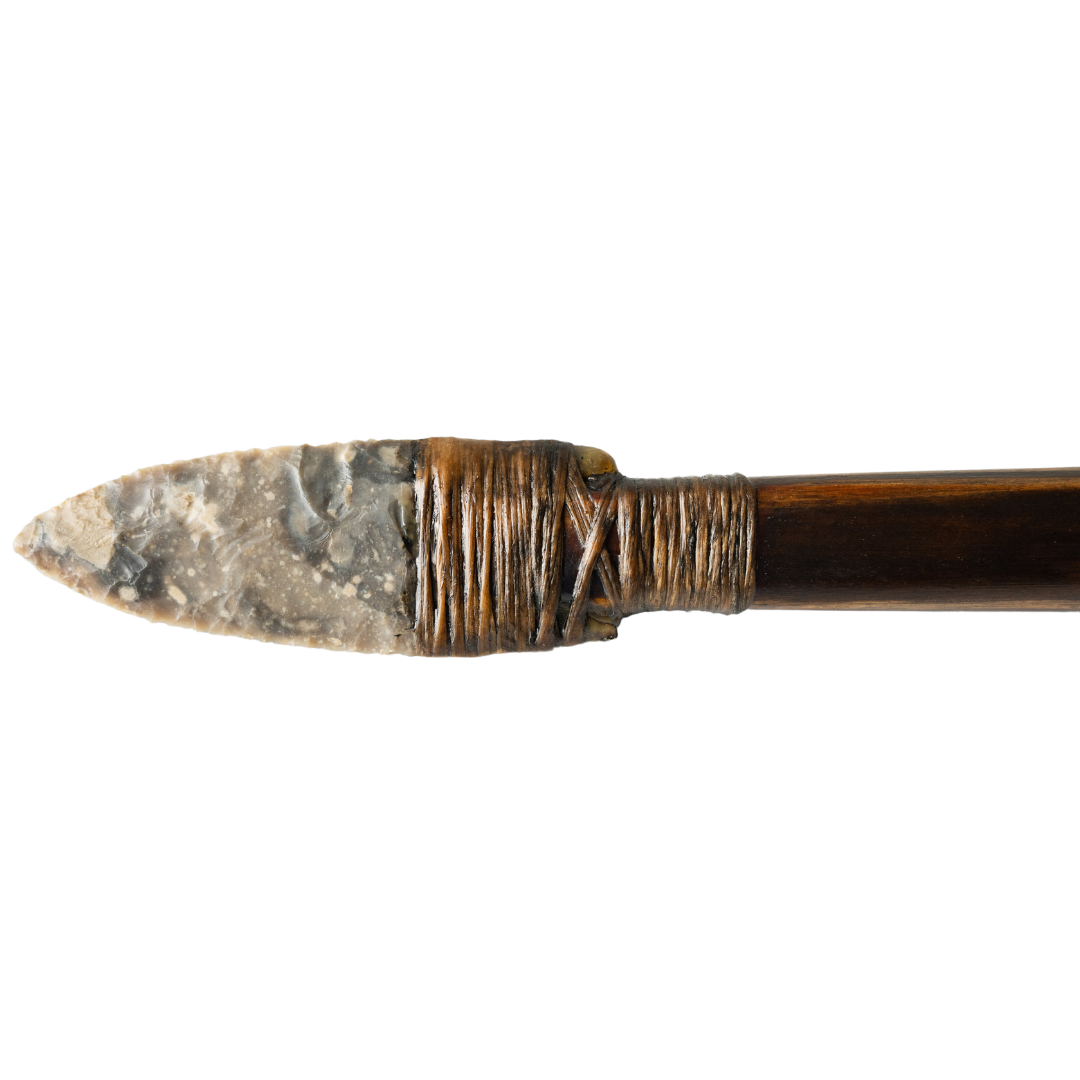 Pale flint spearhead with brown lashing on dark wood shaft.