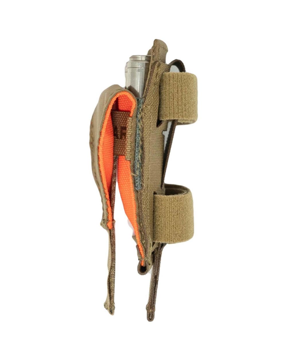 Tan tactical pouch holding an orange and silver tourniquet, with vertical velcro straps.