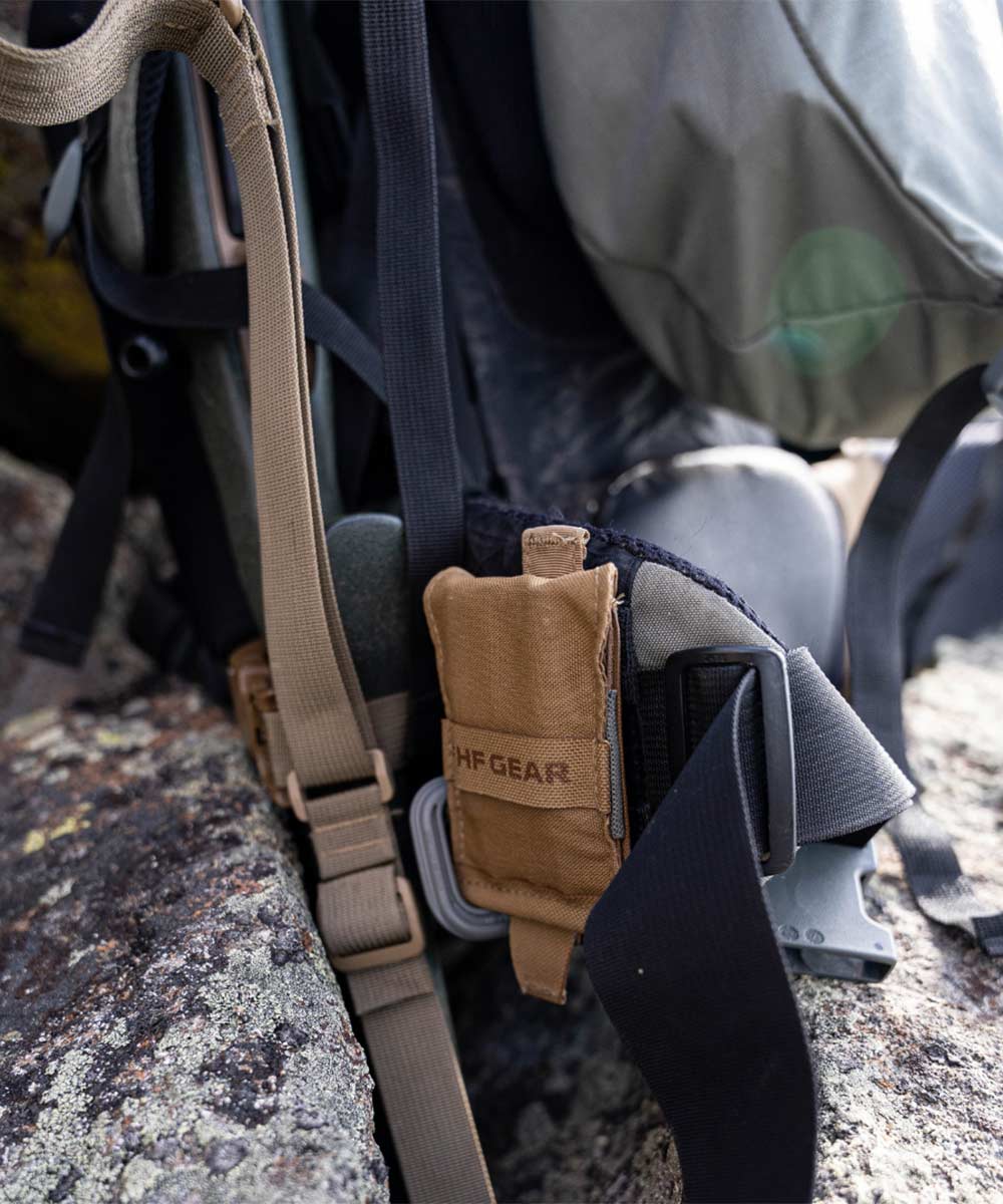 Tan HF GEAR pouch attached to a backpack strap with a gray carabiner.