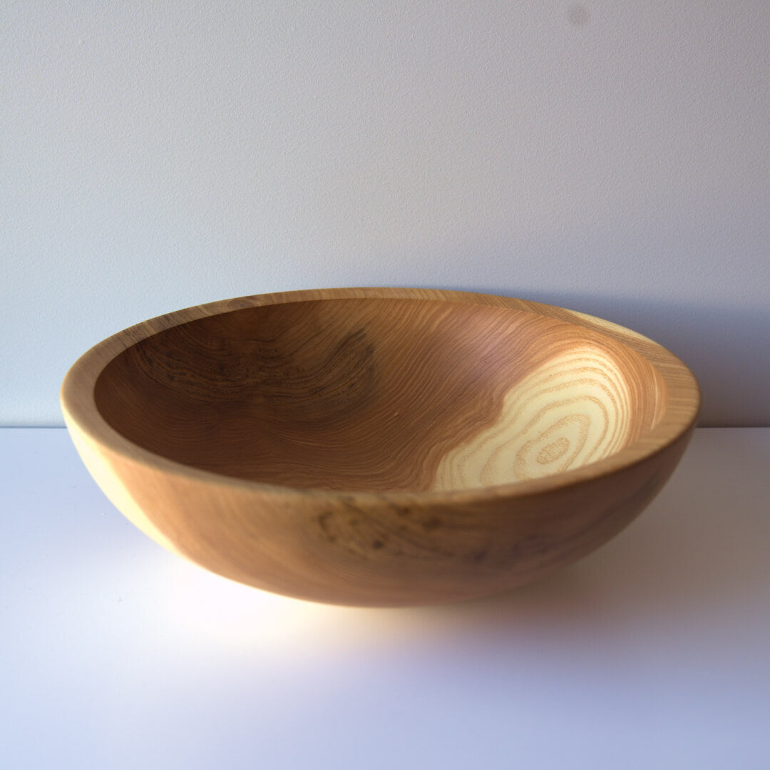 Round wooden bowl with natural light and dark wood grain.