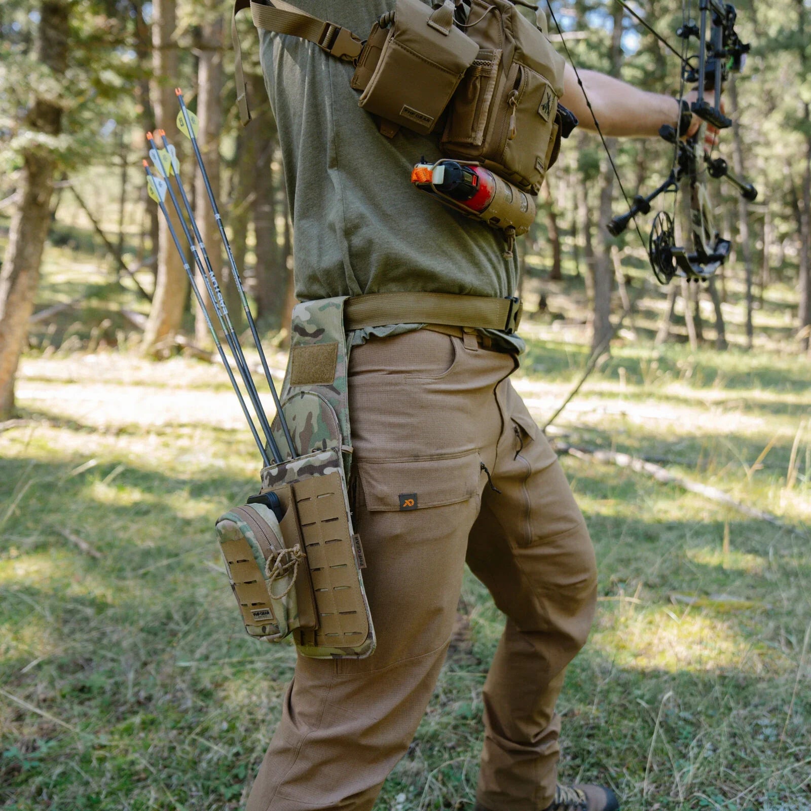 Tan tactical pants with knee panels, multicam quiver holding arrows, and tan chest rig.
