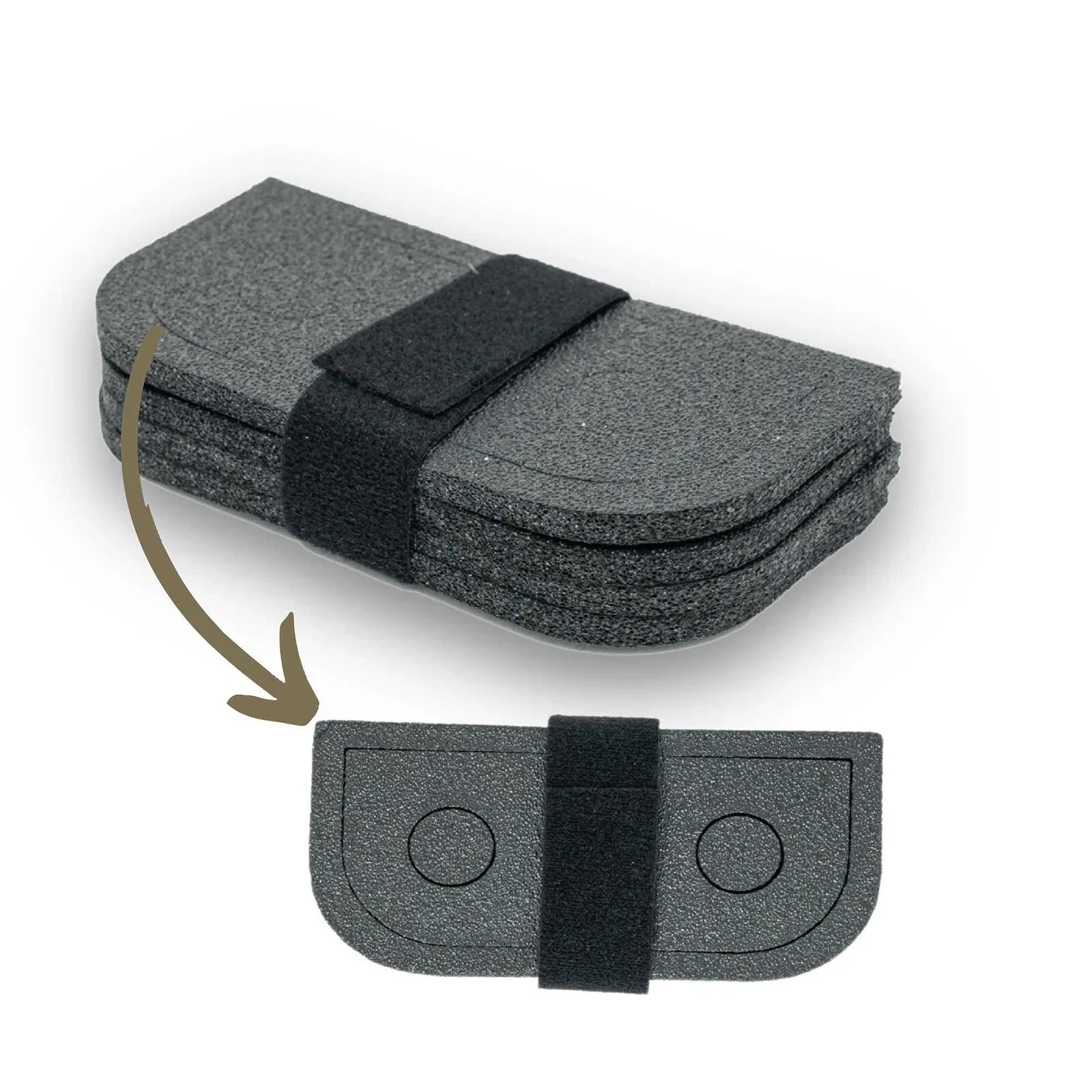 Stack of dark gray textured pads with rounded ends, secured by black velcro strap; one shows circular recesses.