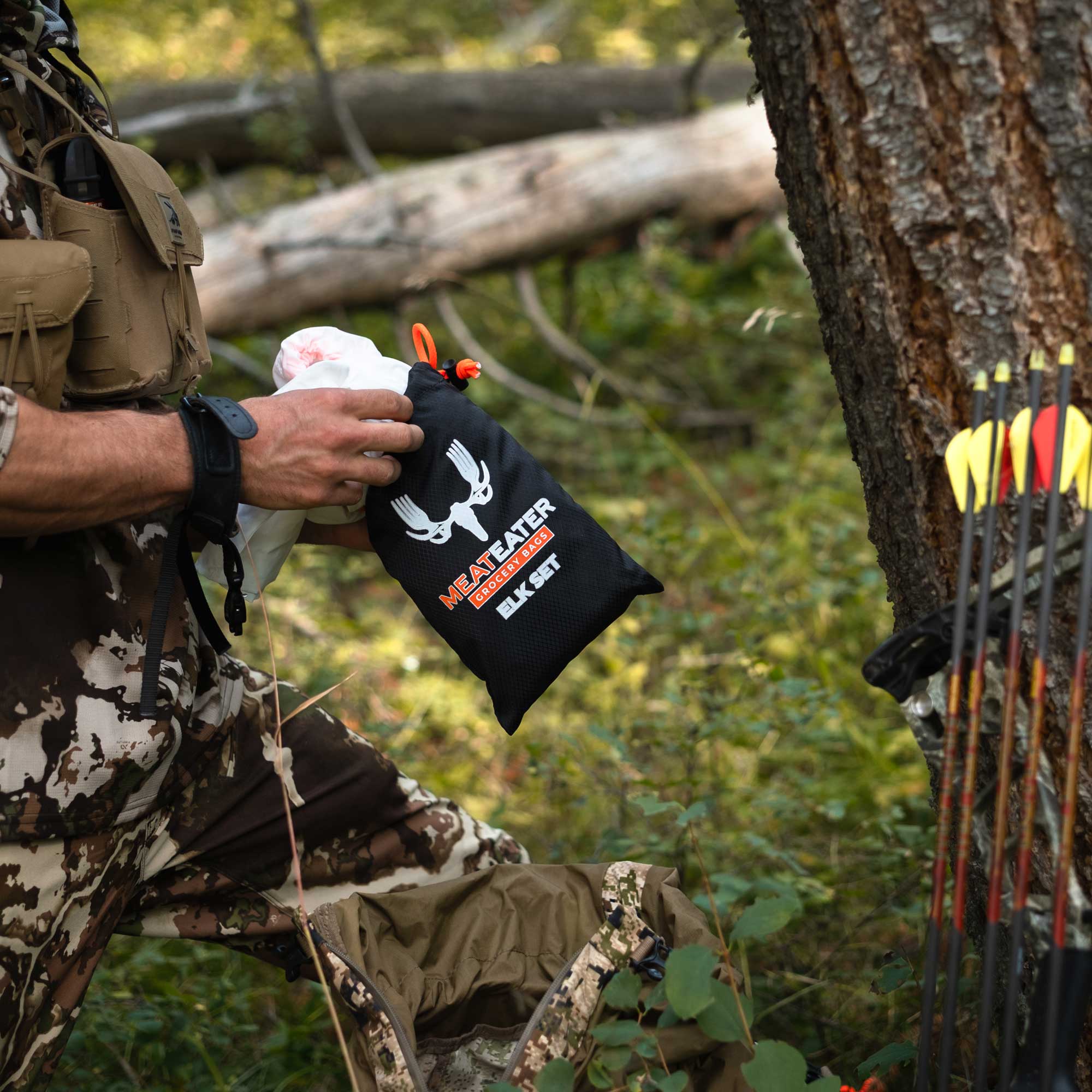 A man with a bow and arrow removing a game bag from a bag saying "MeatEater Grocery Bags Elk Set"