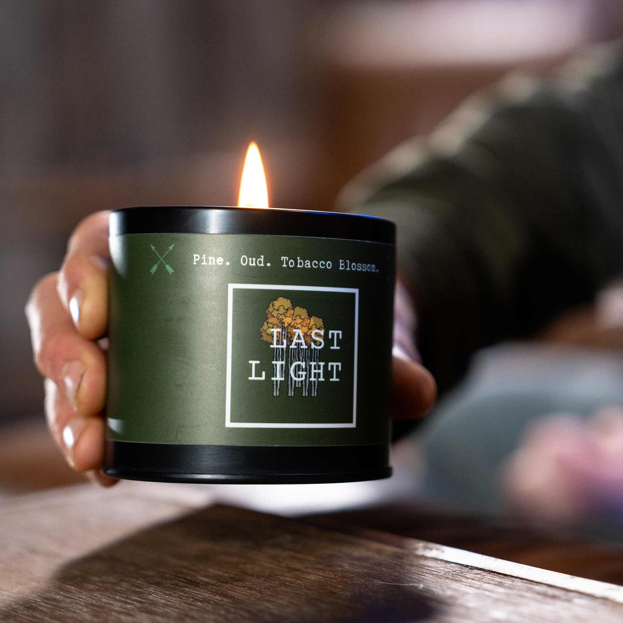 Close up of someone holding scented Last Light candle.