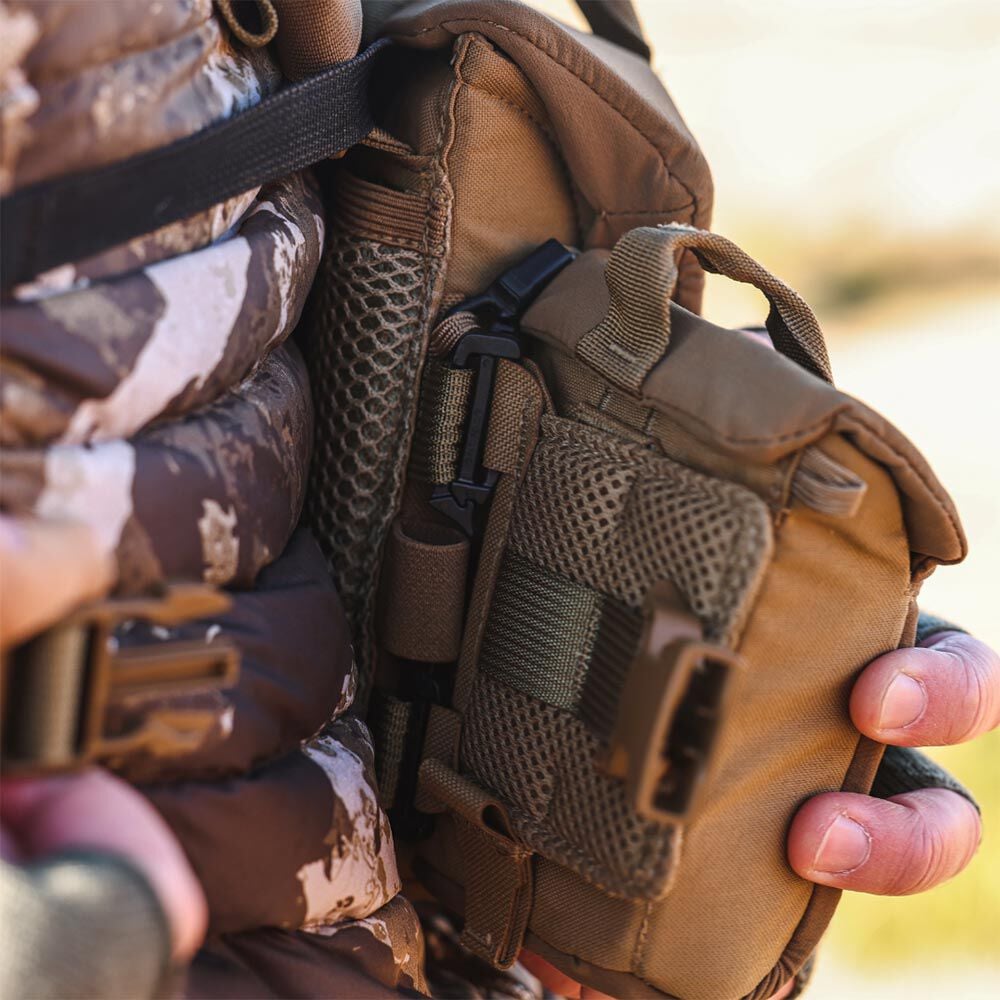 Tan tactical chest pouch with mesh pockets and buckles.