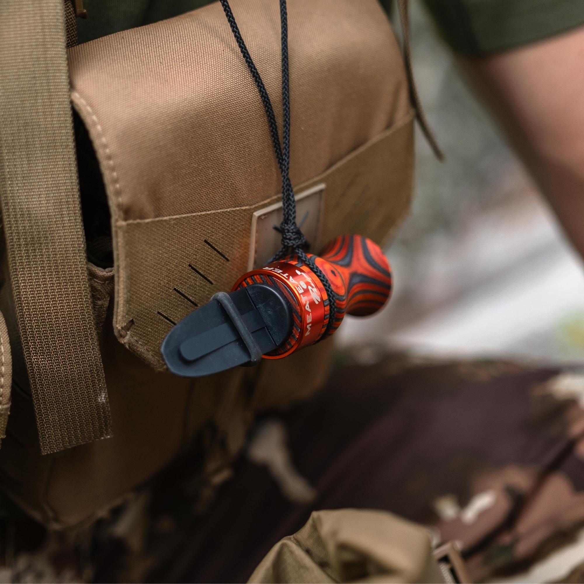 Orange MeatEater x Phelps E-Z Elk Call hanging from a man's neck