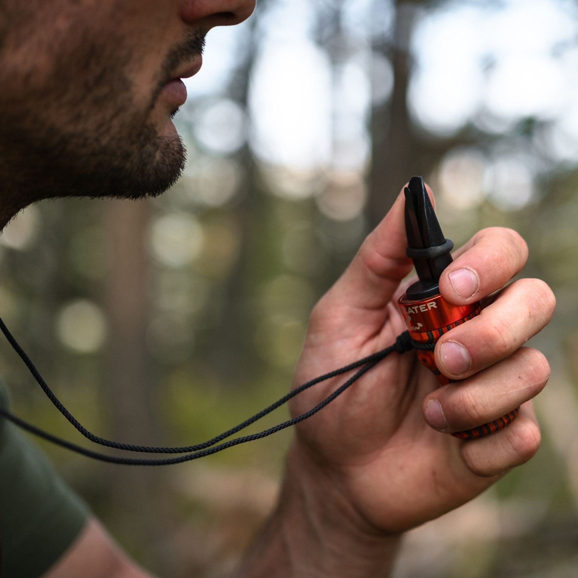 Man holding a MeatEater x Phelps E-Z Elk Call with his left hand