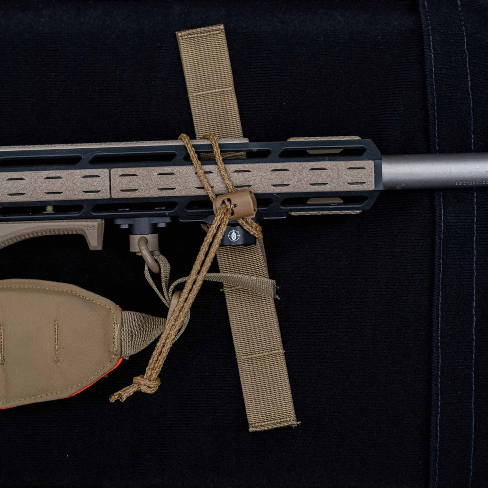 Tan sling, paracord, and cord lock attached to a two-tone M-LOK rifle handguard.