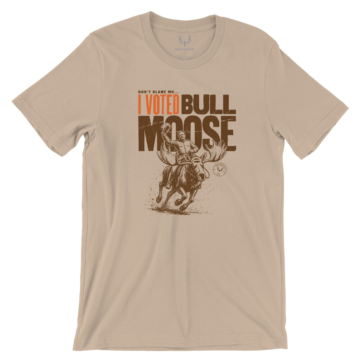 Sandstone T-shirt featuring Teddy Roosevelt riding a running moose and waving a hat, it has the text in brown "DON'T BLAME ME I VOTED BULL MOOSE".