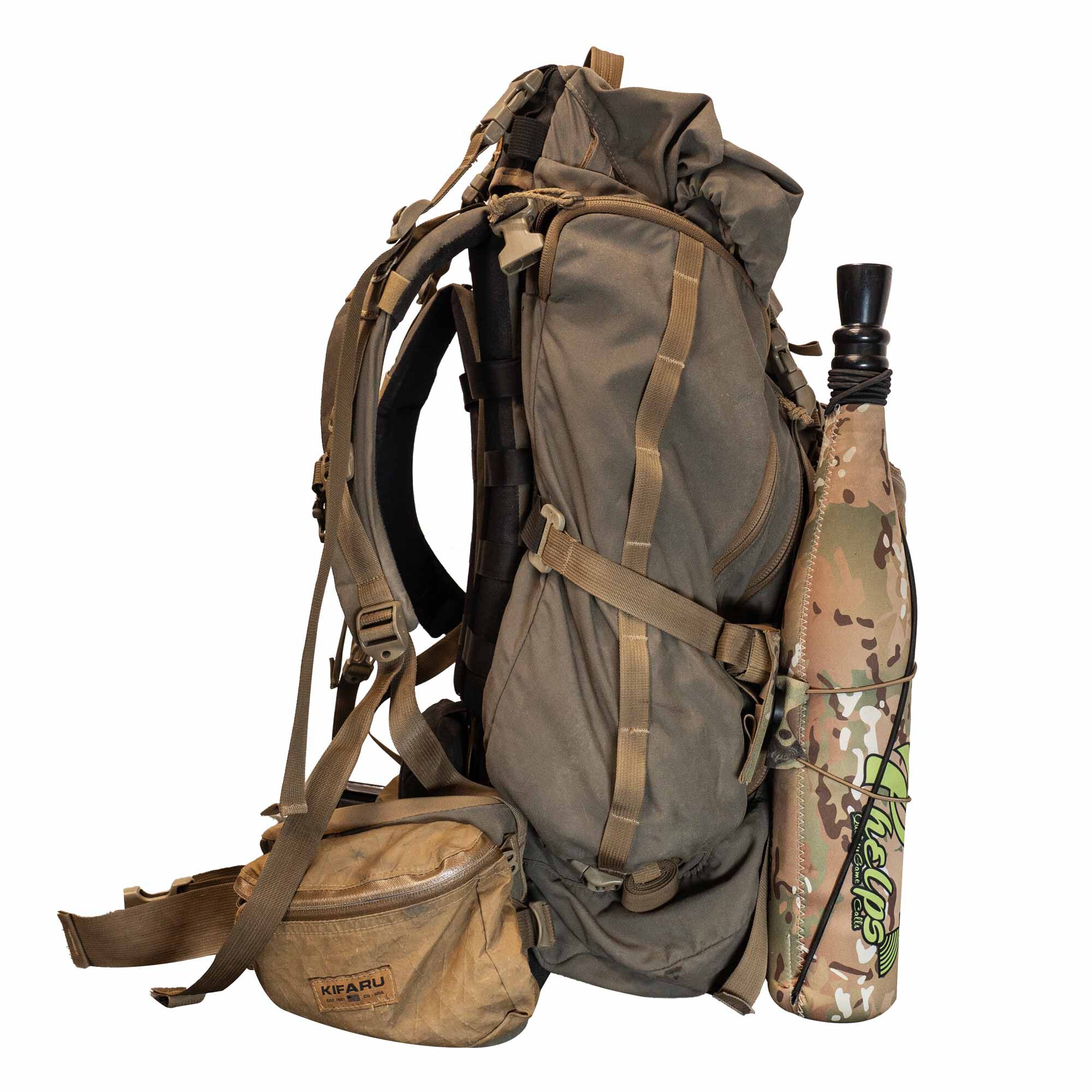 Olive green hunting backpack with a tan fanny pack and camouflage game call holder attached.